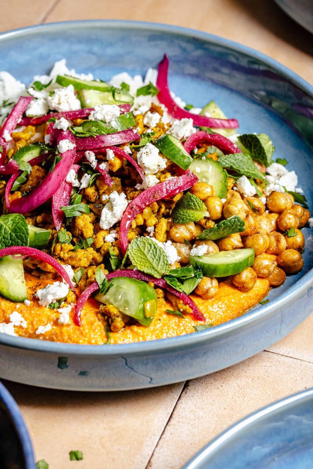 Mediterranean chicken bowl with chickpeas, feta sauce, and fresh herbs