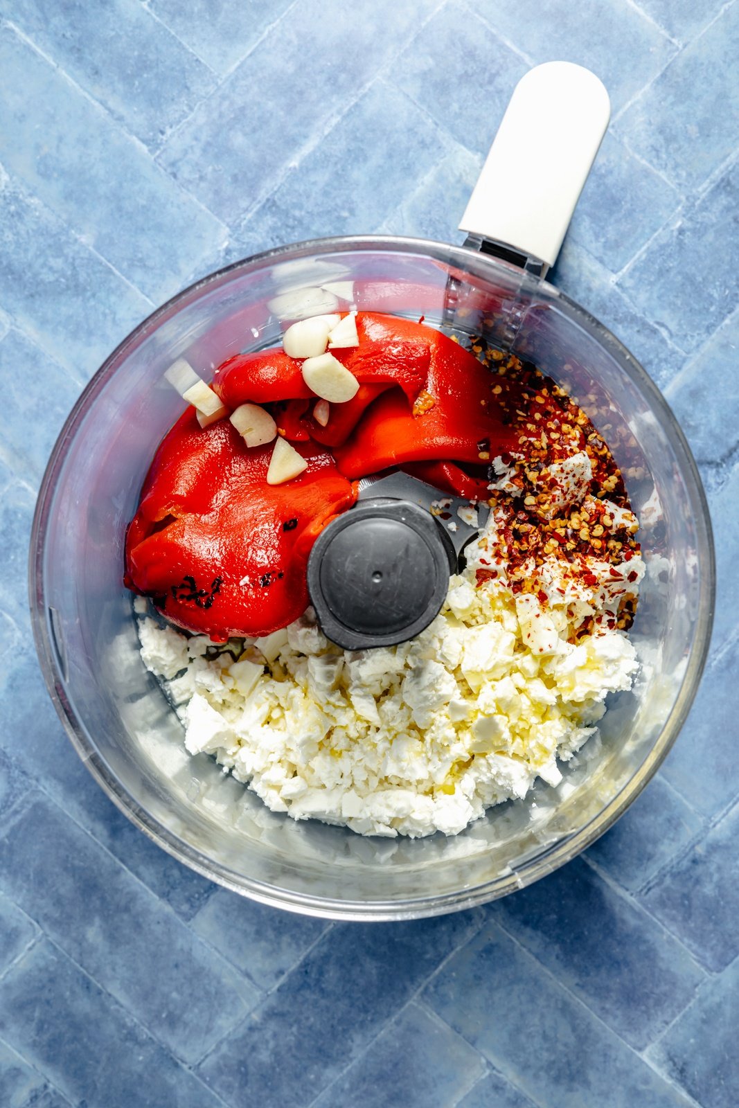 ingredients for red pepper feta dip in a food processor
