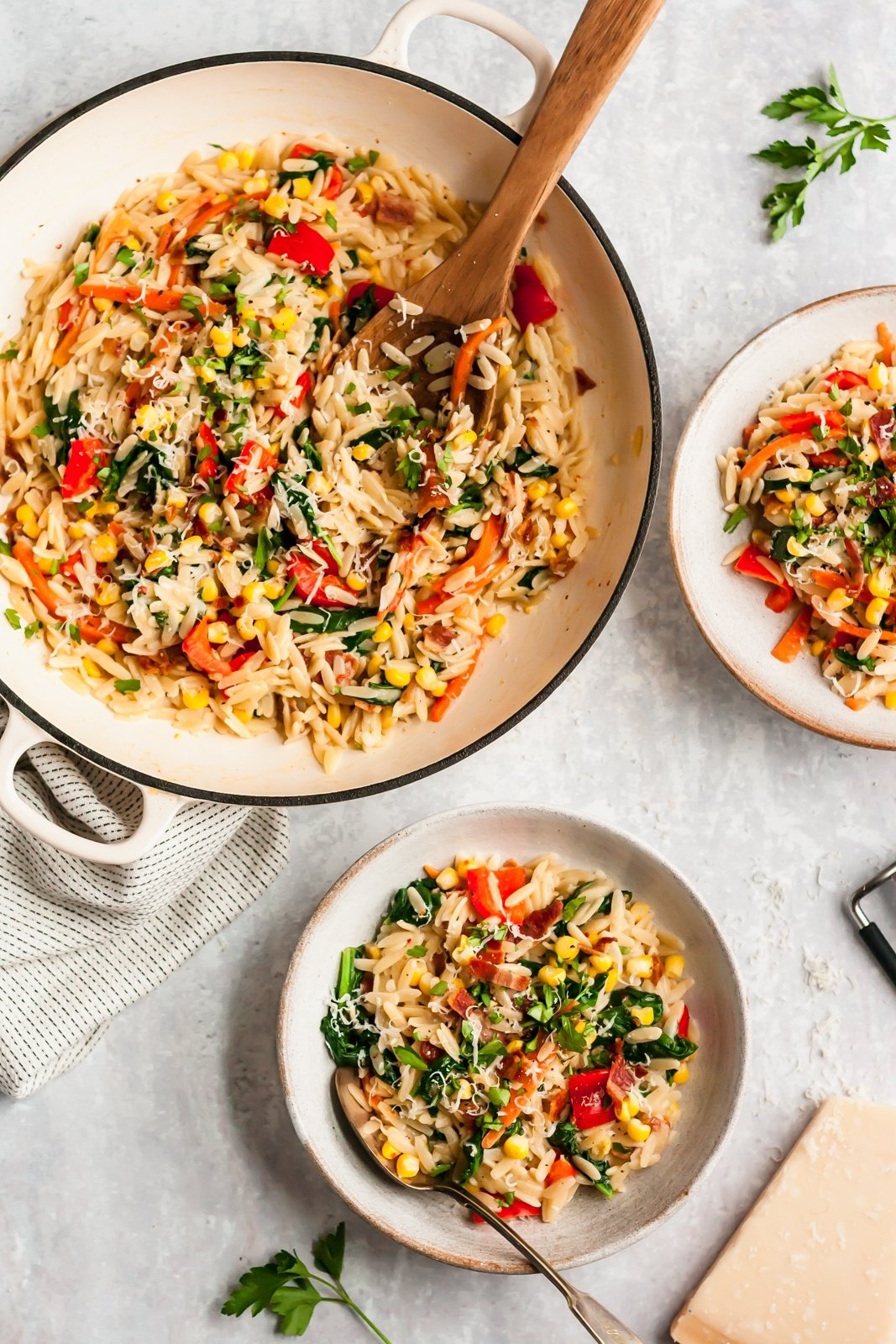 garlic parmesan orzo with vegetables in a pot and in bowls