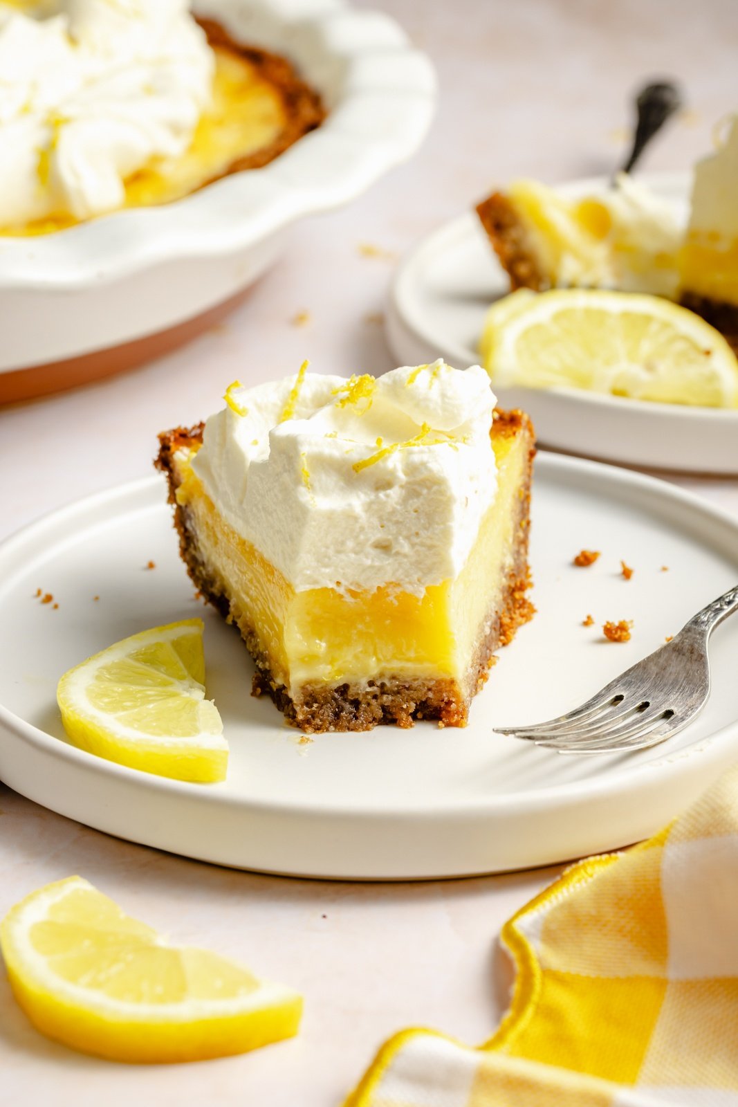 slice of homemade lemon cream pie on a place with a bite taken out