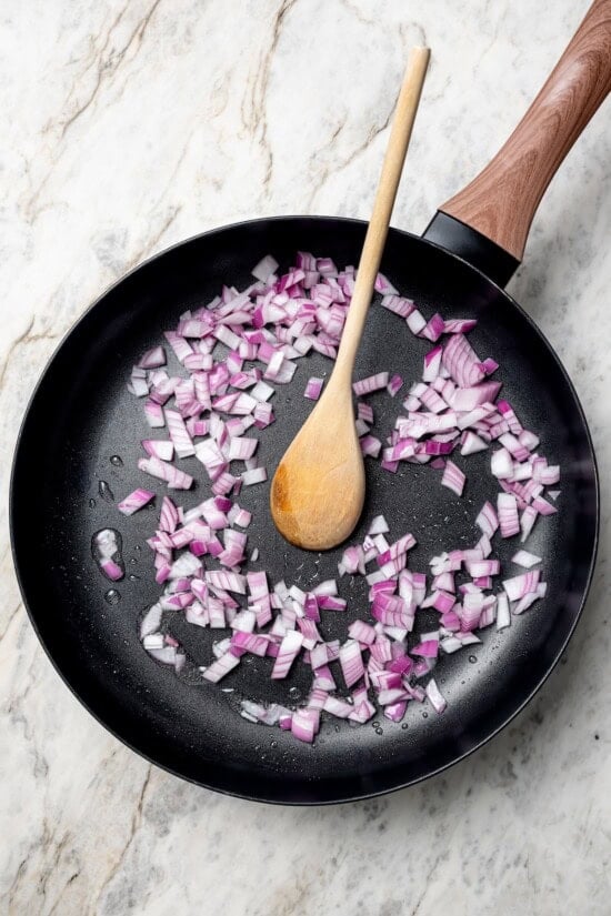 These vegan lentil tacos are easy to make, full of big Tex-Mex flavor and great for meal prep. Add your favorite toppings and dig in! Red onions cooking in skillet