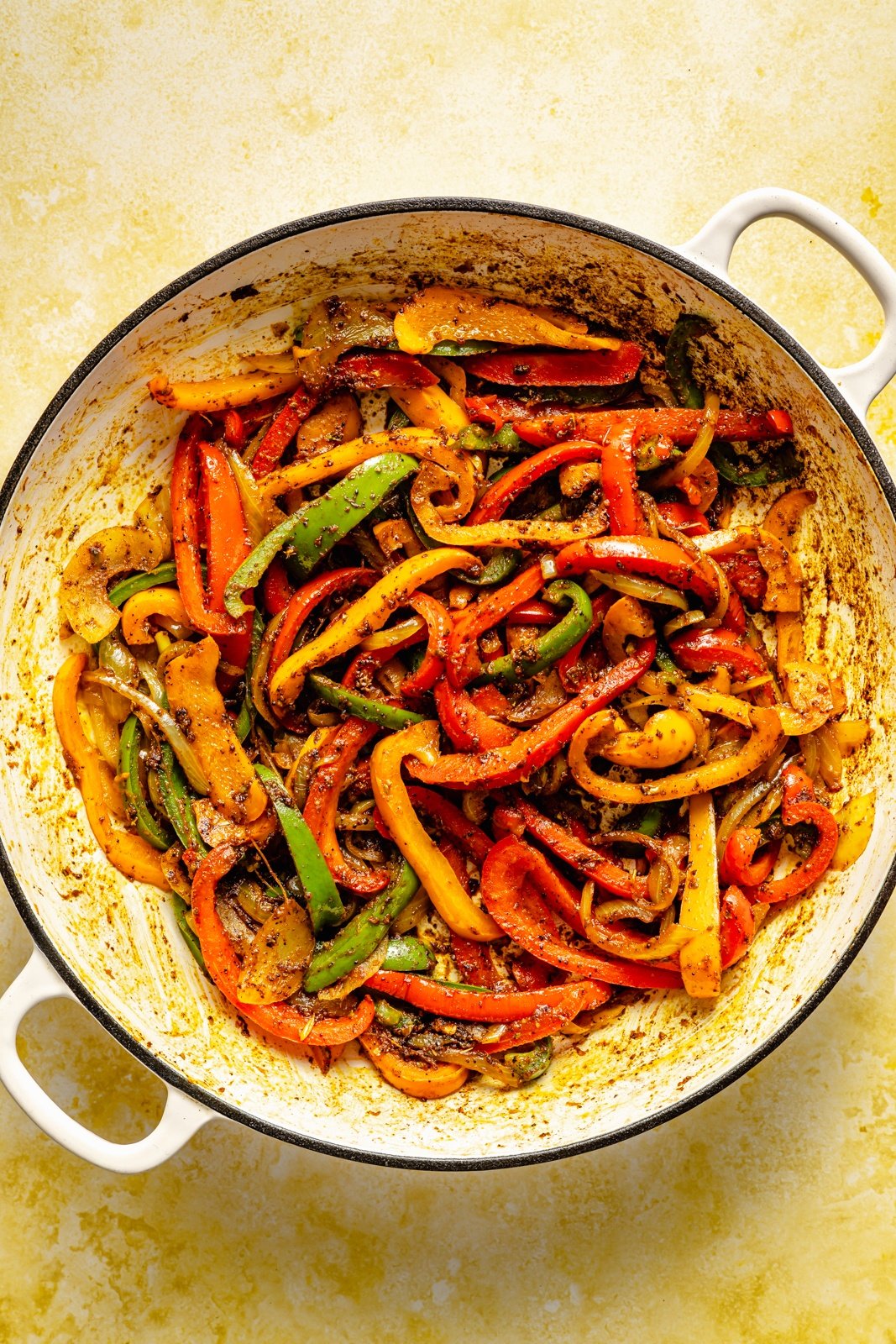 cooking vegetables in a pan for a fajita chicken and rice skillet