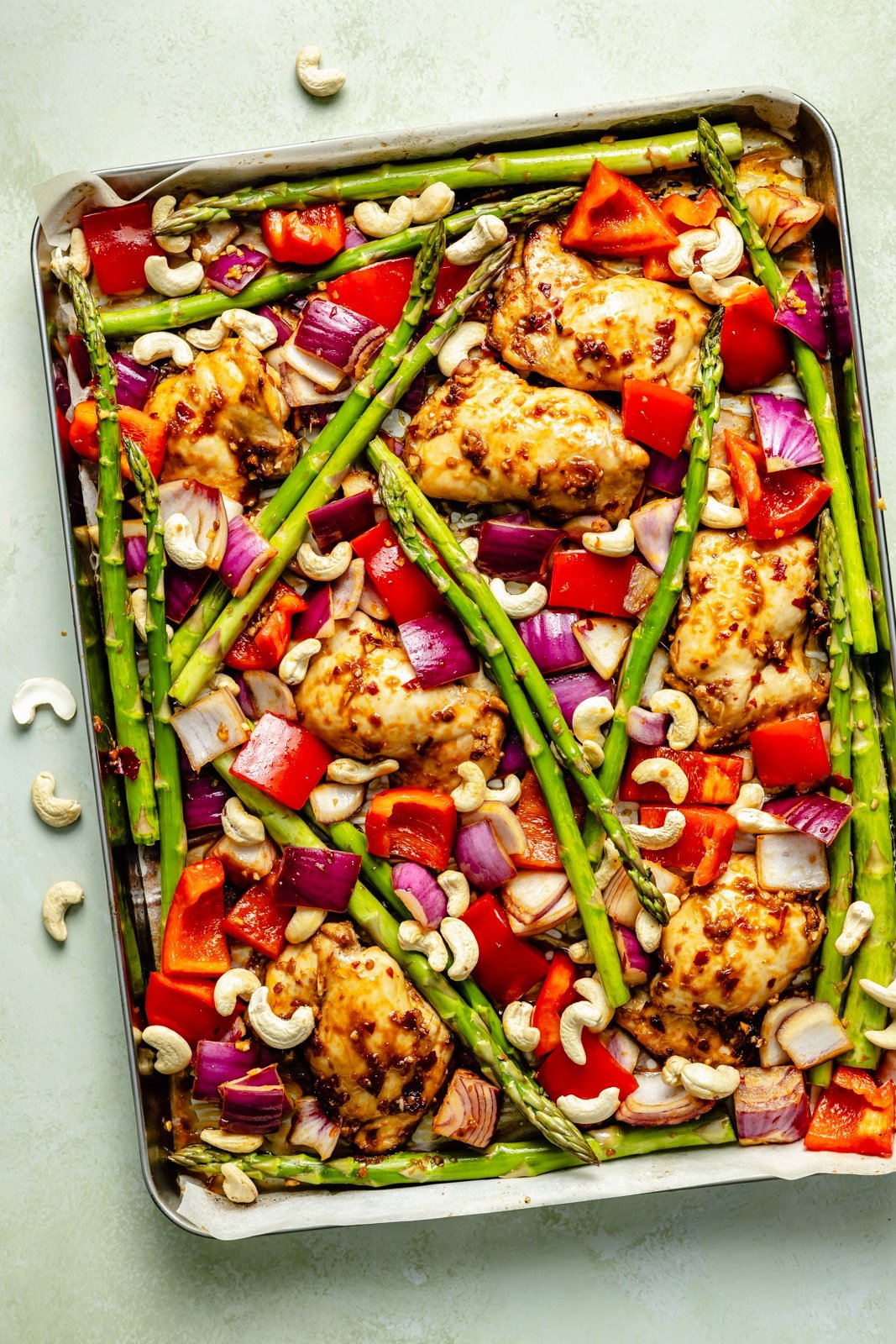 unbaked sesame chicken and vegetables on a sheet pan