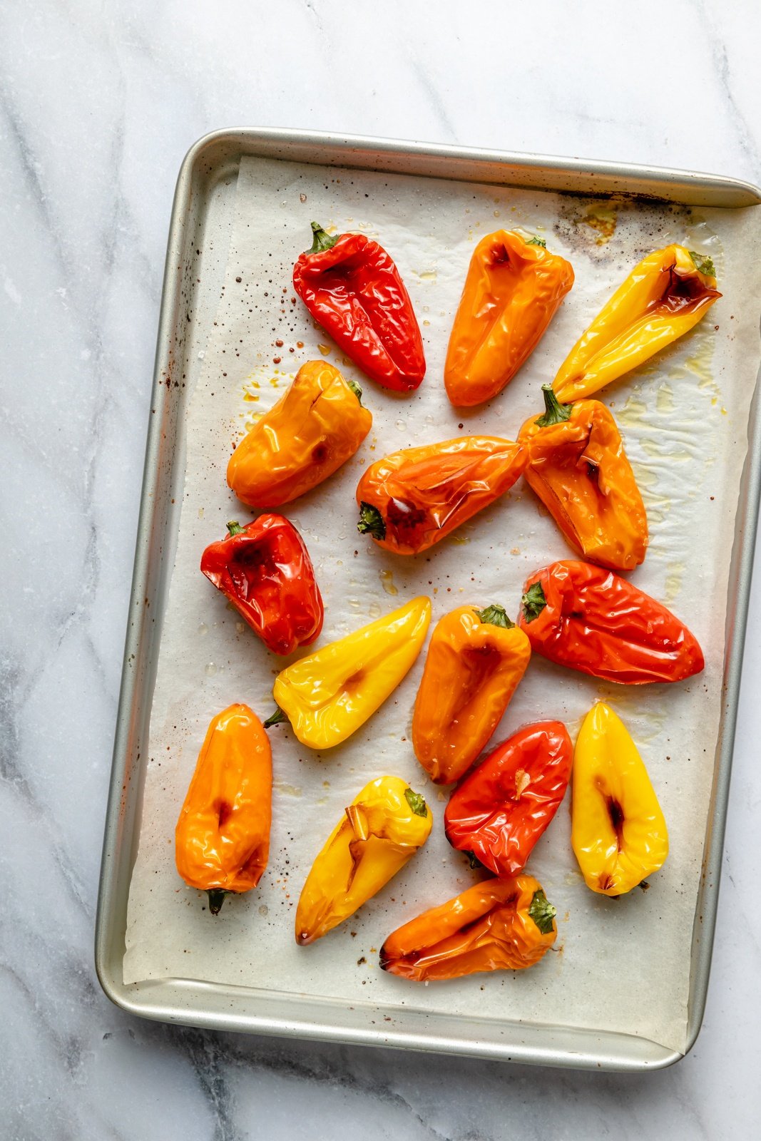 grilled mini peppers on a baking sheet