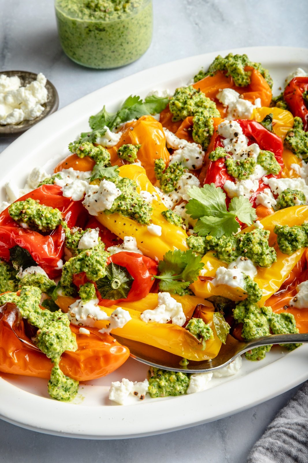 grilled mini sweet peppers topped with goat cheese and pesto