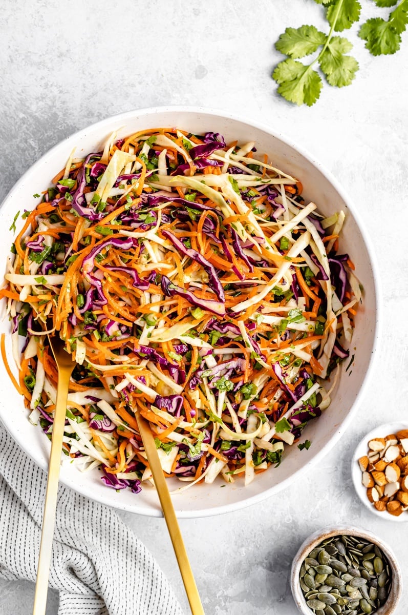 healthy coleslaw in a bowl with two serving spoons