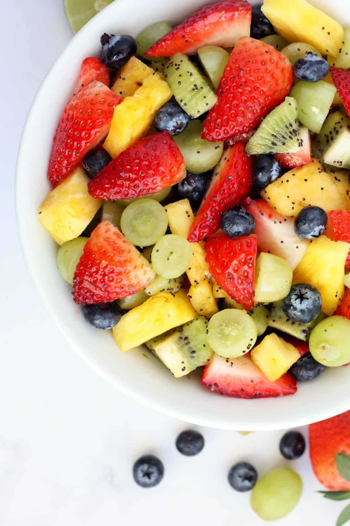 Fruit salad with strawberries, fresh pineapple, blueberries and grapes with a poppyseed dressing.
